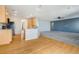 Open concept living space with hardwood floors transitioning into carpet and a modern blue accent wall at 275 Gold Maple St, Brighton, CO 80601