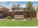 Backyard features a charming porch swing under an arbor, creating a cozy outdoor retreat at 6930 S Yukon Way, Littleton, CO 80128