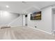 Finished basement area with a large mounted television and neutral carpeting at 6930 S Yukon Way, Littleton, CO 80128
