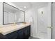 Bathroom vanity featuring a black cabinet, beige countertop, and a large framed mirror at 6930 S Yukon Way, Littleton, CO 80128