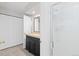 Bathroom view with a vanity with black cabinets, a shower, and closet doors at 6930 S Yukon Way, Littleton, CO 80128