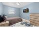 Cozy bedroom featuring blue walls, hardwood floors, a TV and a dresser at 6930 S Yukon Way, Littleton, CO 80128