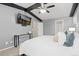 Bedroom featuring vaulted ceilings with dark beams, gray walls, and a flat screen TV on the wall at 6930 S Yukon Way, Littleton, CO 80128