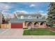 Charming two-story home with a well-manicured lawn, red garage door and inviting front porch at 6930 S Yukon Way, Littleton, CO 80128