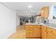 Kitchen with hardwood floors, oak cabinets, and a view of the living room at 6930 S Yukon Way, Littleton, CO 80128