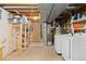 Unfinished basement laundry room featuring a washer, dryer, shelving, and exposed ceiling at 6930 S Yukon Way, Littleton, CO 80128