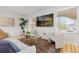 Bright living room with hardwood floors, large windows, and stylish neutral-toned furniture at 6930 S Yukon Way, Littleton, CO 80128