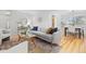 Open-concept living room with hardwood floors, stylish furniture and access to dining area at 6930 S Yukon Way, Littleton, CO 80128