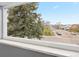 Picture window view includes a large tree and neighborhood houses and streets at 6930 S Yukon Way, Littleton, CO 80128