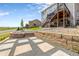 Landscaped backyard features stone pavers, retaining wall and steps leading to a multi-level deck at 6950 Blue Mesa Ln, Littleton, CO 80125