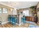 Stylish basement bar area featuring custom wood cabinetry, seating, and decorative pendant lighting at 6950 Blue Mesa Ln, Littleton, CO 80125