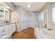 Clean and updated bathroom featuring a soaking tub, glass shower, and modern fixtures at 6950 Blue Mesa Ln, Littleton, CO 80125