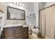 Well-lit bathroom featuring a dark wood vanity, a spacious shower, and a tiled floor at 6950 Blue Mesa Ln, Littleton, CO 80125