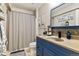 Stylish bathroom features a blue vanity, elegant countertop, and decorative mirror creating a clean, relaxing space at 6950 Blue Mesa Ln, Littleton, CO 80125