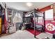 A teen bedroom with a loft bed, desk area, and a bright red accent wall at 6950 Blue Mesa Ln, Littleton, CO 80125