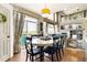 Bright dining area with a round table, modern lighting, and sliding glass doors leading to an outdoor deck at 6950 Blue Mesa Ln, Littleton, CO 80125