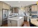A modern kitchen featuring stainless steel appliances, a center island, and custom cabinets at 6950 Blue Mesa Ln, Littleton, CO 80125