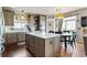 This kitchen features a large island, wooden floors, stainless appliances, and a dining area at 6950 Blue Mesa Ln, Littleton, CO 80125