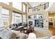 An airy living room with a fireplace, high ceilings, and large windows overlooking the backyard at 6950 Blue Mesa Ln, Littleton, CO 80125