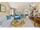 An open-concept living room featuring a dining area with a staircase leading to the upper floor at 6950 Blue Mesa Ln, Littleton, CO 80125