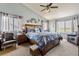 Comfortable bedroom with a large bed, plush seating, and lots of natural light from multiple windows at 6950 Blue Mesa Ln, Littleton, CO 80125