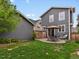 Landscaped backyard features a stone patio with dining set, an umbrella, and a comfortable lounge chair at 2880 Emporia Ct, Denver, CO 80238