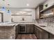 Basement wet bar with granite countertop, stylish backsplash, and stainless steel appliances at 2880 Emporia Ct, Denver, CO 80238