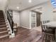 View of the finished basement featuring a staircase and wet bar with chairs at 2880 Emporia Ct, Denver, CO 80238