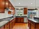 Well-lit kitchen with stainless steel appliances, hardwood floors, and dark granite countertops at 2880 Emporia Ct, Denver, CO 80238