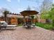Outdoor dining patio features a brick surface, a dining set with umbrella, and pergola with climbing vines at 2880 Emporia Ct, Denver, CO 80238