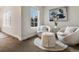 Bright sitting room with an abstract painting, chairs, an ottoman, and a window providing natural light at 2880 Emporia Ct, Denver, CO 80238