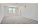 Light-filled bedroom featuring soft carpeting, and large windows with neighborhood views at 2916 Oxley St, Strasburg, CO 80136