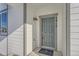 Gray front door with a welcome mat, and exterior light fixture at 2916 Oxley St, Strasburg, CO 80136