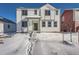Charming two-story home featuring white siding, gray trim, and a welcoming front porch in a snowy setting at 2916 Oxley St, Strasburg, CO 80136