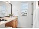 Well-lit powder room features vanity, framed mirror, faucet, and window at 3815 Red Deer Trl, Broomfield, CO 80020