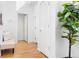Bright hallway with hardwood floors and neutral decor, featuring a comfortable bench and decorative houseplant at 3815 Red Deer Trl, Broomfield, CO 80020