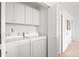 Efficient laundry room equipped with a washer, dryer, storage cabinets, and easy access at 3815 Red Deer Trl, Broomfield, CO 80020