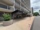 Condominium building entrance featuring a covered entrance with glass doors, planters, and a glimpse of balconies at 888 N Logan St # 2C, Denver, CO 80203