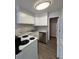 Well-lit kitchen with white cabinets and a stainless steel dishwasher at 888 N Logan St # 2C, Denver, CO 80203