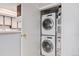 Efficient laundry area with stacked washer and dryer units, located near the kitchen for easy access at 17053 E Tennessee Dr # 212, Aurora, CO 80017