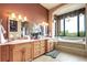 Bright bathroom featuring double sinks, granite countertops, a large mirror, and a soaking tub at 580 Summer Mist Cir, Castle Rock, CO 80104