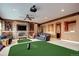 Spacious entertainment room with a fireplace, golf simulator, and comfortable seating at 580 Summer Mist Cir, Castle Rock, CO 80104