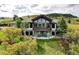 Stunning two-story home featuring a wall of windows, stone accents, and a spacious patio with outdoor seating at 580 Summer Mist Cir, Castle Rock, CO 80104