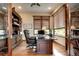 Traditional home office featuring hardwood floors, wood shelves, and a spacious desk with scenic outdoor views at 580 Summer Mist Cir, Castle Rock, CO 80104
