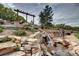 Beautiful tiered rock waterfall feature with lush landscaping and a decorative pergola overhead at 580 Summer Mist Cir, Castle Rock, CO 80104