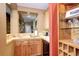 Modern wet bar with wood cabinets, stone countertops, and a wine glass display at 580 Summer Mist Cir, Castle Rock, CO 80104