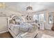 Bright bedroom with a decorative white bed, desk area, a decorative mirror, and sheer curtains at 286 Claymoor Ct, Castle Pines, CO 80108