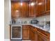 Butler pantry featuring granite counters, cabinets, beverage cooler and sink offers style and convenience at 286 Claymoor Ct, Castle Pines, CO 80108