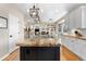 Open-concept kitchen with granite island, modern lighting, and hardwood floors at 286 Claymoor Ct, Castle Pines, CO 80108