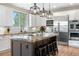 Stylish kitchen with white cabinets, granite island, and stainless-steel appliances at 286 Claymoor Ct, Castle Pines, CO 80108